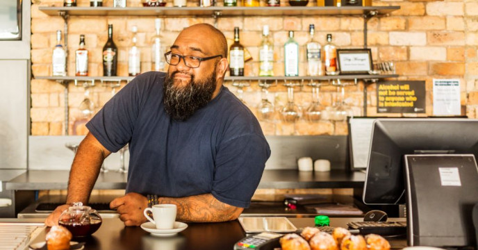 Cafe owner leaning on counter top