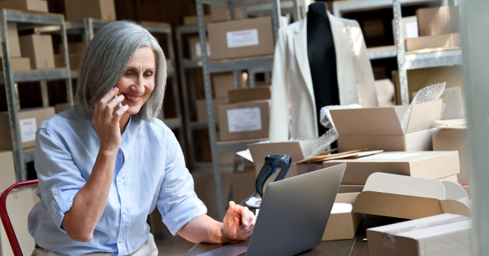 Older woman talking on phone and using laptop